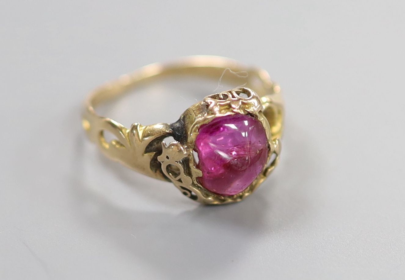 An early 20th century yellow metal and red cabochon set oval ring, size K/L, gross weight 2.4 grams.